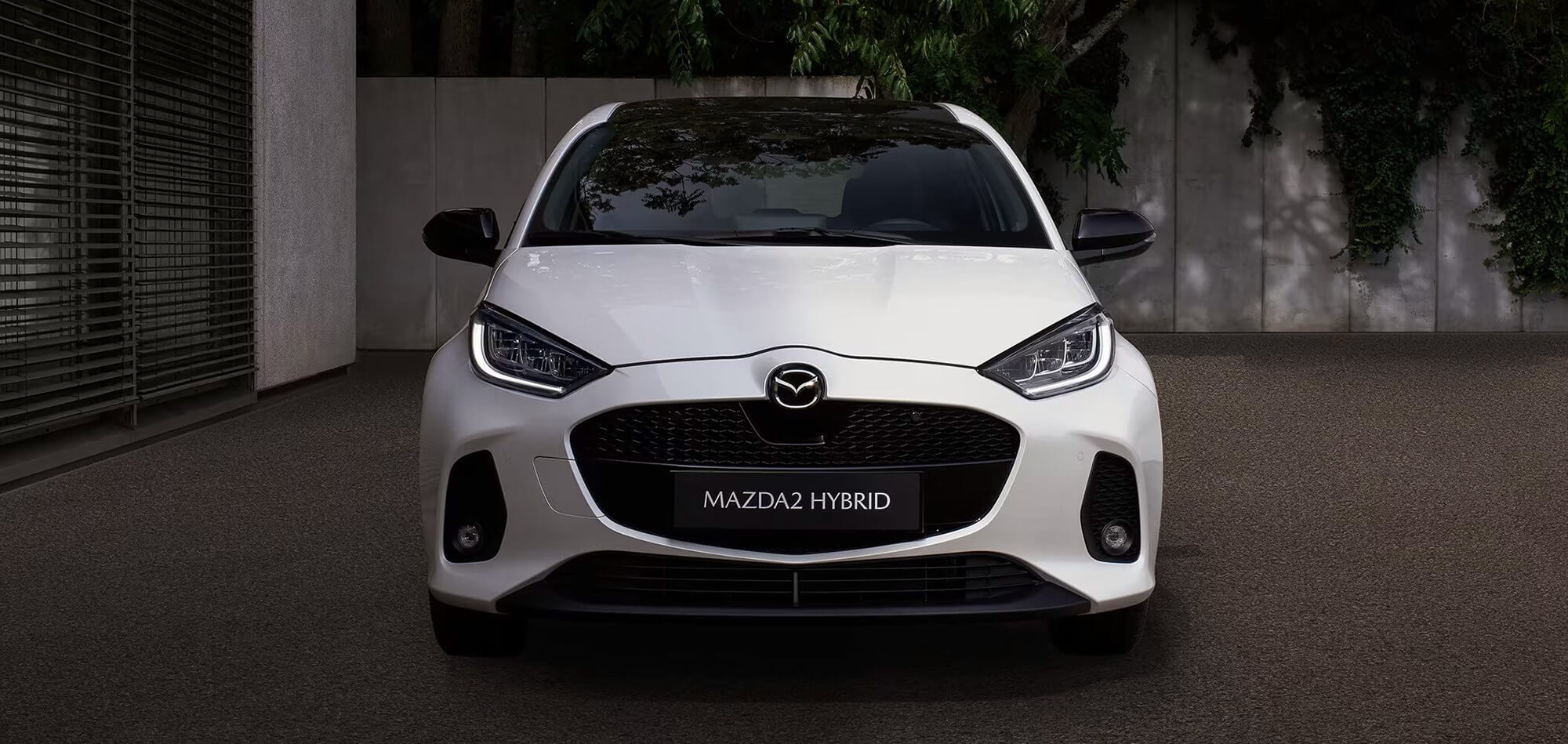 White Mazda2 Hybrid car front view.